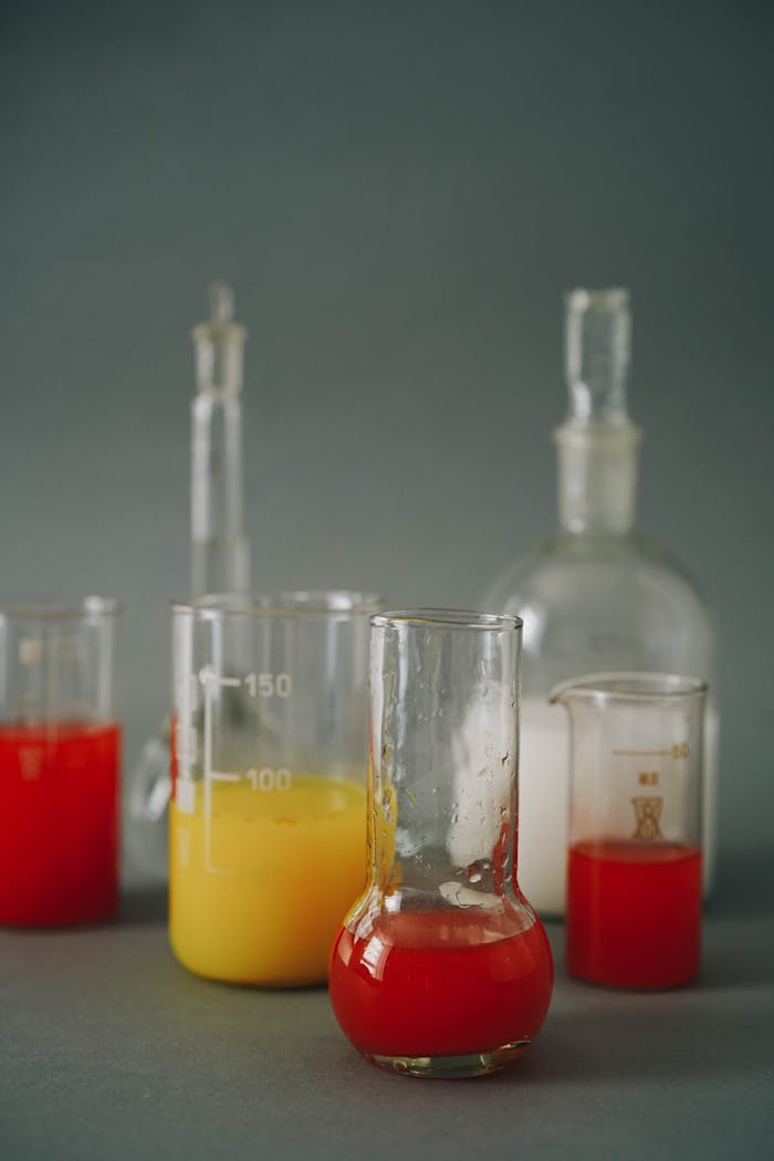 about-us Close-up of laboratory flasks filled with colorful liquids for chemistry experiments.